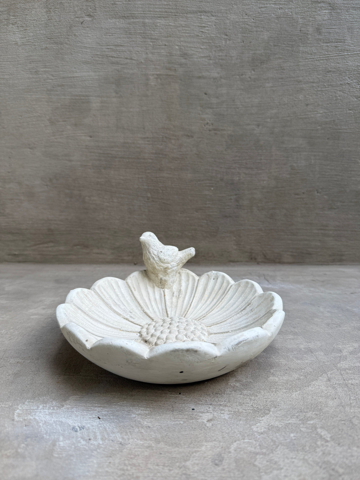 Fuente para pájaros de cemento con forma de flor y pajarito